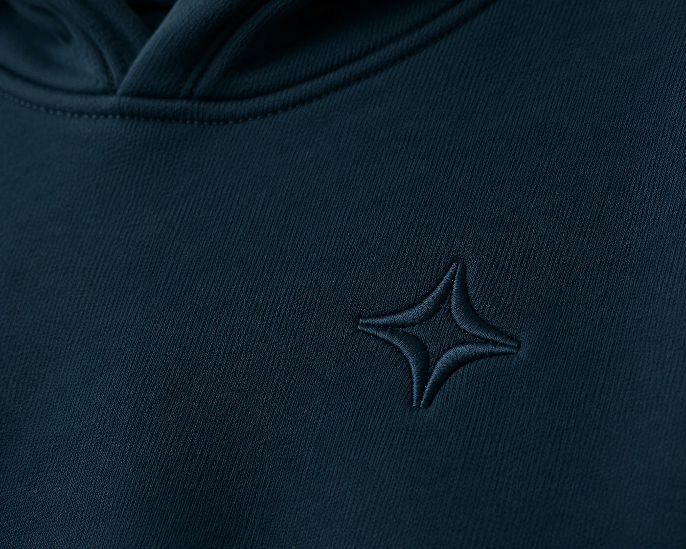 Close-up of tonal embroidery on a navy hoodie