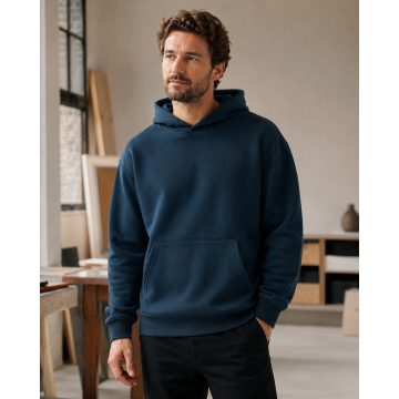 Custom Hoodie editorial visual direction worn by a male model in a creative studio.